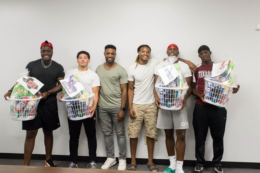 young men posing with gift baskets